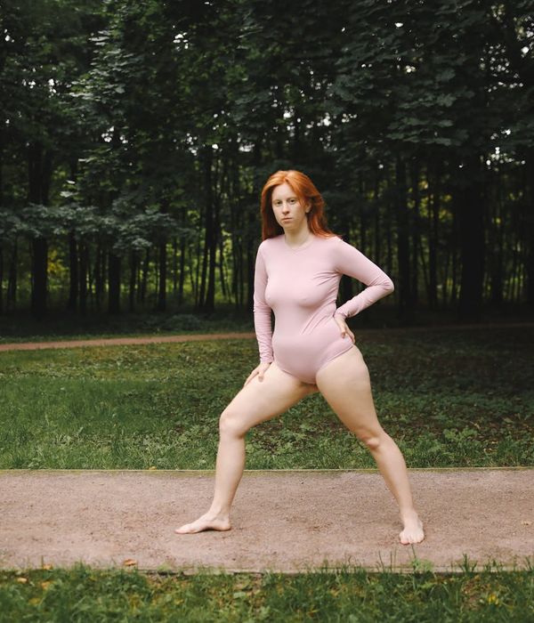 Person stretching outdoors, looking peaceful and healthy.
